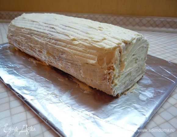 Сворачиваем рулет швом вниз, смазываем оставшимся кремом.