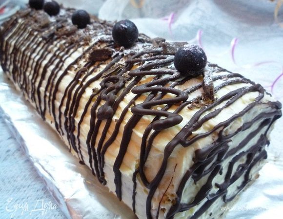 Украшаем рулет растопленным шоколадом и ягодами черной смородины, посыпаем сахарной пудрой.