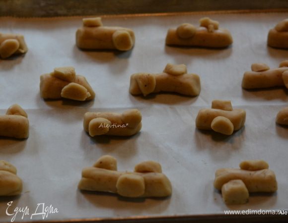 Взять несколько колбасок нарезать тонко, присоединить к каждому раскатанному кусочку, формируя в бревнышко. 