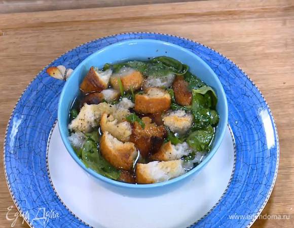 В глубокую тарелку выложить крутоны, кинзу и шпинат, залить все горячим бульоном, так чтобы шпинат немного привял, затем посолить, поперчить и добавить еще сухариков.