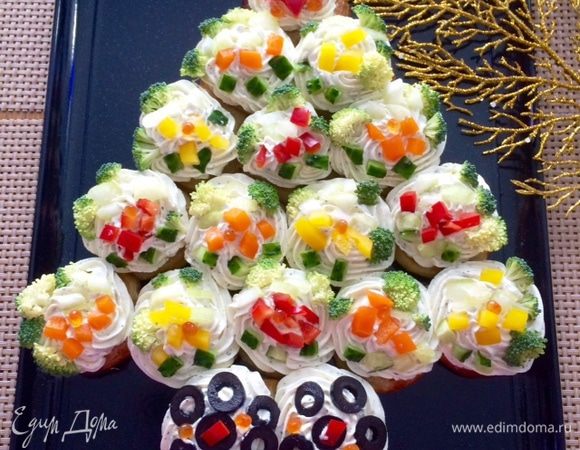 Раскладываем "украшения" по своему желанию.
"Верхушку" я украсила звездой из болгарского перца, а "ствол" елки нарезанными маслинами.