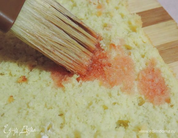 Пропитываем бисквит клубничным сиропом. У меня клубника замороженная с сахаром, я ее размораживаю для крема и жидкость сливаю — получаю натуральный клубничный сок с сахаром. Им я и пропитываю бисквит. 
Если у вас такого сиропа нет, вы можете взять сироп из клубничного варенья и немного разбавить его водой. Или же просто пропитать бисквит сахарным сиропом из воды и сахара.
Мне понадобилось приблизительно 250 мл пропитки.