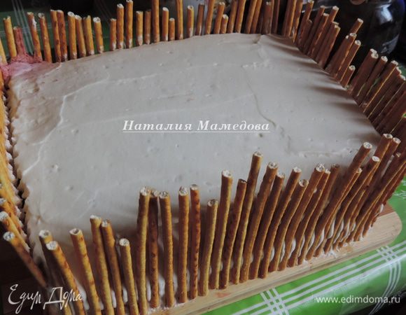 Далее я бока торта оформила соломкой, имитируя заборчик вокруг сказочного дворика. Мне понадобилось примерно 500 г соломки. Я каждую соломку обламывала до нужной длины, а ее остатки утилизировали дети.