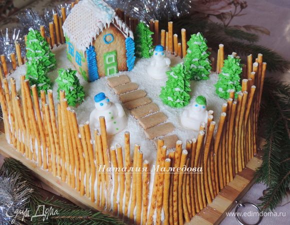 Торт сверху щедро посыпаем кокосовой стружкой, чтоб от сливочного крема айсинг не начал подтаивать. А затем выставляем наши украшения: домик, снеговиков, елки. Из кусочков печенья "бамбук" я дополнительно выложила дорожку.