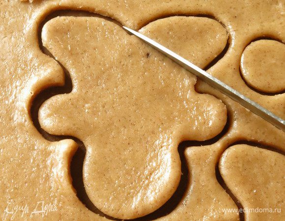 Присыпаем стол мукой, раскатываем тесто, вырезаем формочкой, переносим на пергамент, на половине фигурок отрезаем "ногу печенюшки" как на макете, корректируем мордочку — делаем ее более округлой. 