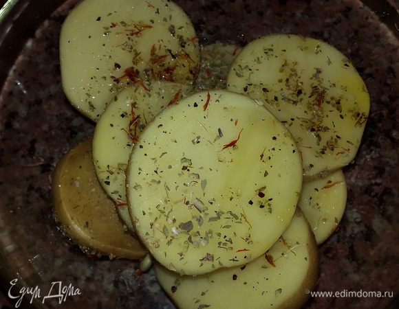 Картофель моем, разрезаем вдоль на две части, солим, перчим, добавляем тимьян, шафран и оливковое масло. Перемешиваем руками.