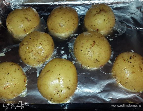 Выкладываем картофель на противень застеленный фольгой срезом вниз и ставим запекаться при температуре 170°C до готовности. Примерно 35 минут.