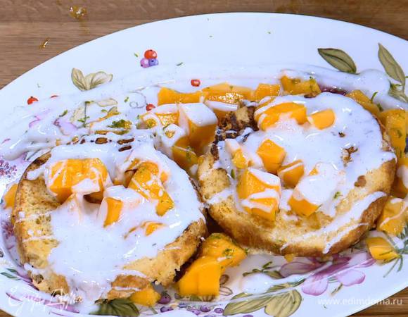 Обжаренные тосты поместить на манго, часть кусочков манго выложить на тосты и полить все йогуртовым соусом.