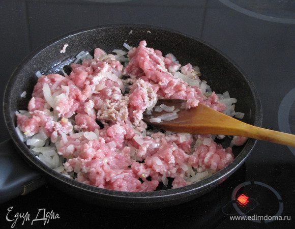 Пока тесто подходит, займемся начинкой. Почистить и измельчить лук. Разогреть в сковороде 1-2 ст. л. растительного масла и обжарить лук до прозрачности. Выложить фарш и готовить, помешивая и разбивая комочки. Когда фарш будет готов, убрать сковороду с огня. Посолить и поперчить по вкусу.
