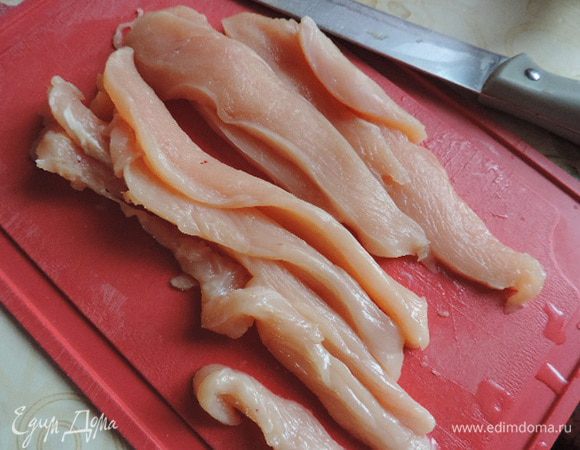 За 3-5 часов (а можно и за сутки) до начала приготовления блюда надо замариновать курочку. Для этого филе нарезаем вдоль волокон на тоненькие полоски.
