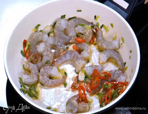 Добавить креветки и обжарить их вместе с овощами почти до готовности.