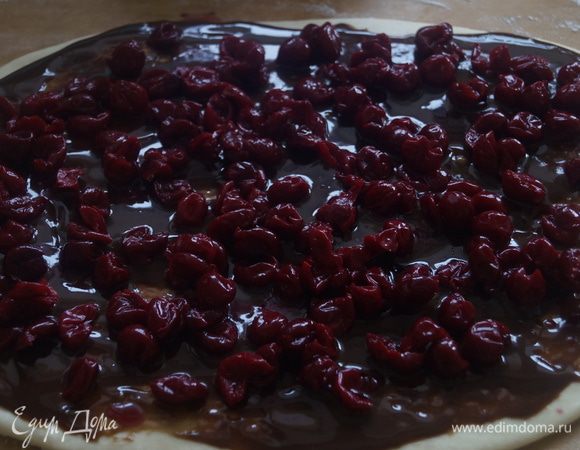 Достать тесто и раскатать в пласт примерно 25х35 см, толщиной 8-10 мм.

Намазать пласт шоколадным кремом, разложить вишню. Предварительно вишневый сок слить.