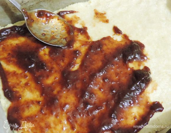 Раскатываем второй песочный корж, размером с первый. Смазываем его кислым сливовым джемом (повидлом), можете заменить его на другое на ваш вкус, но обязательно с кислинкой.