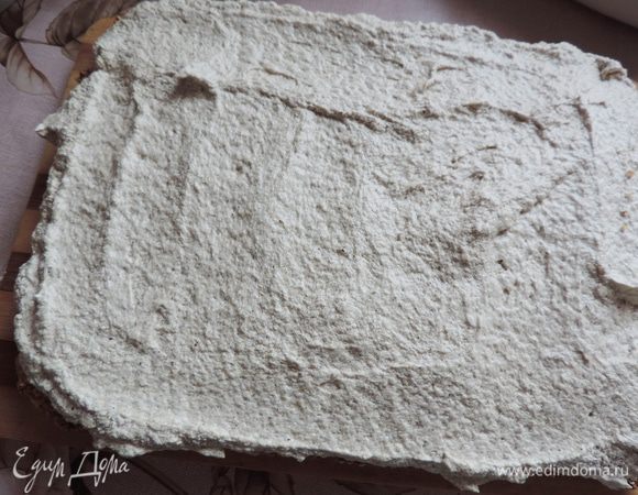 На блюдо выкладываем корж с кунжутом кунжутом вверх. На него выкладываем весь крем и равномерно распределяем (я оставила несколько ложек для того, чтобы обмазать бока пляцка).