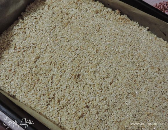 По подготовленному коржу равномерно распределяем горячий (!) кунжут. 