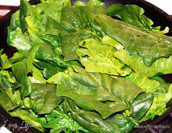 Готовим начинку. Шпинат хорошо промыть, убрать стебельки. Чеснок мелко порубить. Разогреть на сковороде растительное масло, слегка обжарить чеснок, пока он даст свой аромат. Выложить на сковороду шпинат. 