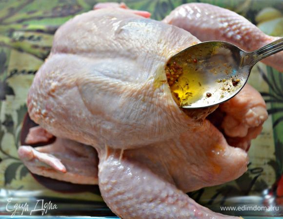 На грудке нашей курочки аккуратно приподнимите кожу и с помощью ложки заполните образовавшееся пространство подготовленной масляно-горчичной смесью. Проделайте тоже самое со стороны спинки. Слегка промасируйте кожу, помогая равномерно распределиться смеси. 