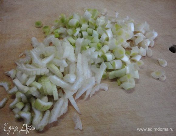 Белую часть лука нарезать колечками, также нарезать сельдерей и слегка обжарить на двух ложках растительного масла.