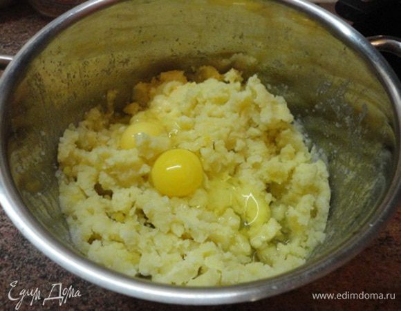 К этому времени картофель уже будет готов. Слейте воду, разомните, добавьте 70 г сливочного масла, 2 яйца и один белок (желток и 30 г сливочного масла оставим для смазки пирога), а также муку и замесите негустое тесто.