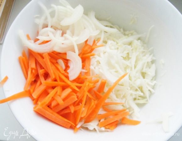 Капусту нарезать соломкой, морковь тонкими полосками, лук полукольцами. Все помять руками, полить лимонным соком, добавить щепотку сахара и перемешать. Убрать салат в холодильник на 10-15 минут, чтобы слегка промариновался.