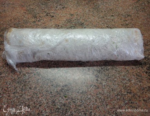 Накрыть последним листом лаваша, затем плотно свернуть рулет, завернуть в пищевую пленку и положить в холодильник на 2 часа.