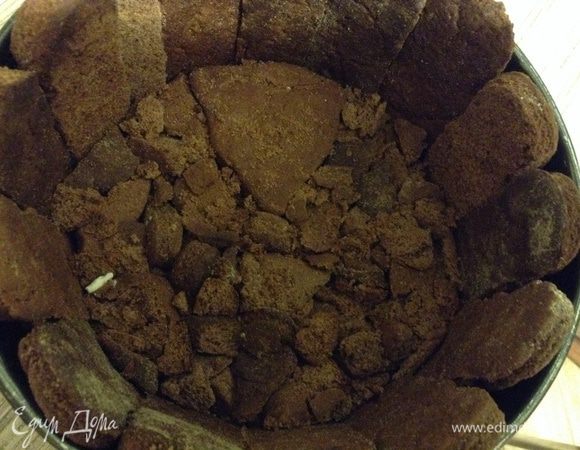 Дно формы проложить пленкой, выставить "заборчик" из пряников, а кусочки остатков плотно утрамбовать на дно.