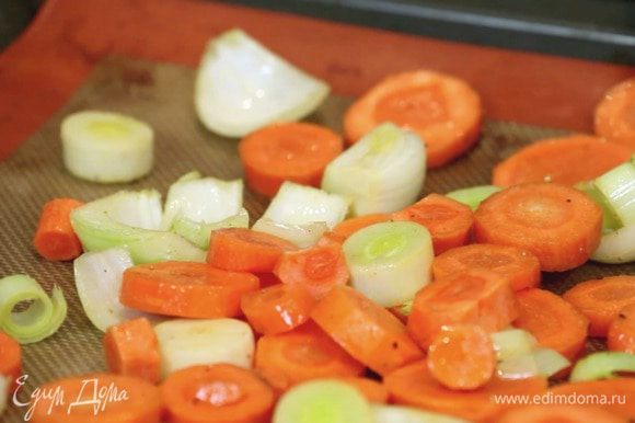 Нарезать морковь и 2 вида лука. Полить маслом, посолить, выложить на противень и запекать 30 минут при температуре 220°С.