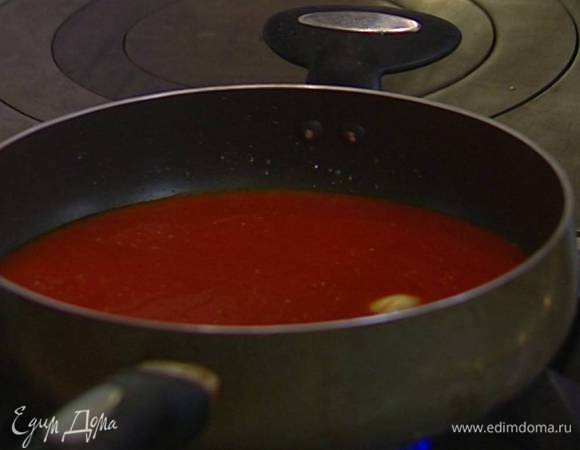 Разогреть в сковороде 2–3 ст. ложки оливкового масла, добавить раздавленный чеснок, затем помидоры и уваривать соус на медленном огне в течение 15 минут, чтобы он слегка загустел. 