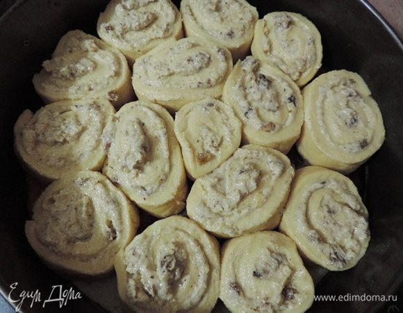 Полученные рулетики уложить в вертикальном положении на расстоянии 1 см друг от друга в неразъемную (!) форму диаметром 26 см. На дно формы можно положить бумагу для выпечки, бортики смазать маслом. 
Если вы все же используете разъемную форму, обязательно оберните ее фольгой, чтобы молоко во время выпечки из нее не вытекало.