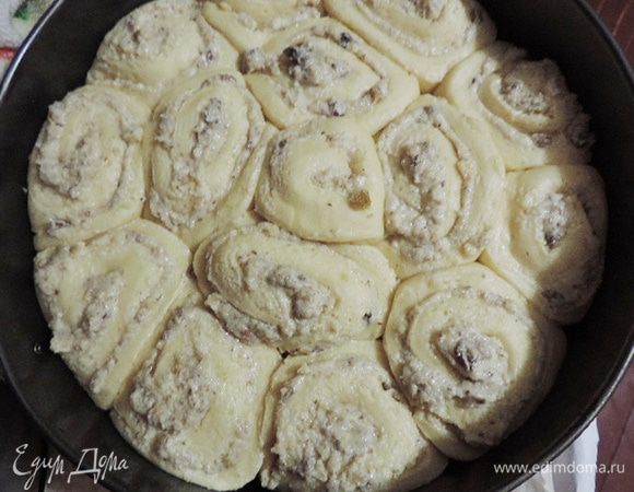 Оставить форму в теплом месте примерно на час (до тех пор, пока рулетики настолько увеличатся в объеме, что заполнят всю форму). Пока пирог расстаивается, приготовить заливку. Для этого молоко нагреть вместе с сахаром. Помешивая, дождаться полного растворения сахара и остудить до комнатной температуры.