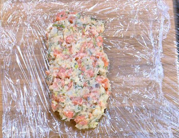 Пищевую пленку расстелить на рабочей поверхности, выложить рыбный фарш, сформировать из него прямоугольник толщиной 2‒3 см, завернуть в пленку и отправить на несколько минут в морозильник.