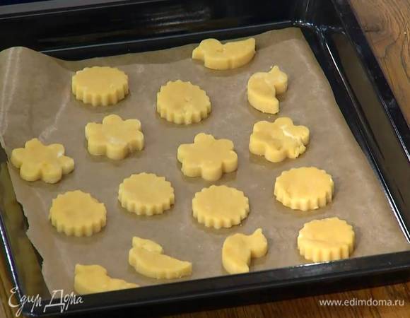 Кондитерскими формочками вырезать фигурки и выложить их на противень, выстеленный бумагой для выпечки.