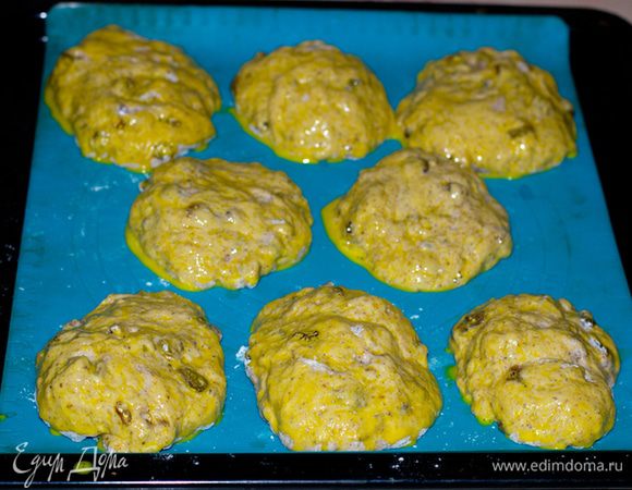Через 20 минут налепил плюшки и поместил на противень. Включил духовку прогреваться, а тем временем добавил в желток.
чайную ложку воды и смазал будущие булки.