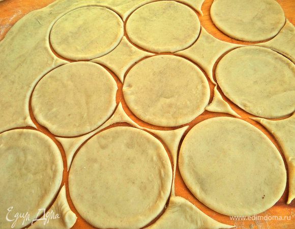 Достаём тесто (я отрезала большую половину, вторая половина в следующем рецепте), немного нагреваем его в комнате, так легче раскатывать. Раскатываем тонко на муке и вырезаем кружочки шириной 7 см.