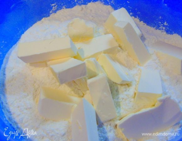 В просеянную муку добавляем соль, сахар и кусочками нарезанное сливочное масло.