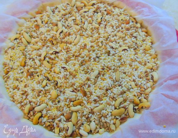 Накрываем пергаментом и сверху насыпаем груз. Отправляем в разогретую до 180°С духовку на 12 минут, затем снимаем груз и еще выпекаем 3-5 минуты.