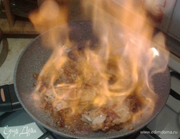 Слегка подогрейте бренди (коньяк) и влейте в мясо, подожгите.