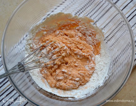 Добавить к соку воду, цедру апельсина, растопленное масло, соль, дрожжи, желток и половину муки.