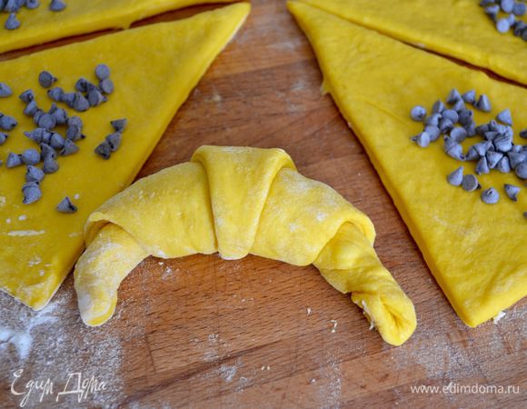 В середине основания треугольника сделать надрез 1-2 см и свернуть от широкого края к узкому, придав форму круассана.