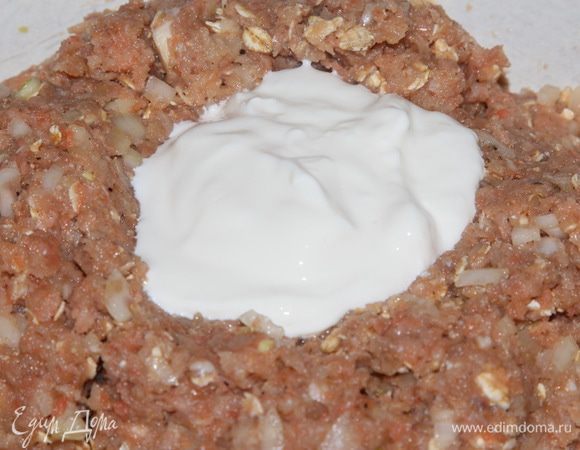 В вымешанный фарш добавляем две столовые ложки сметаны и снова хорошенько вымешиваем.