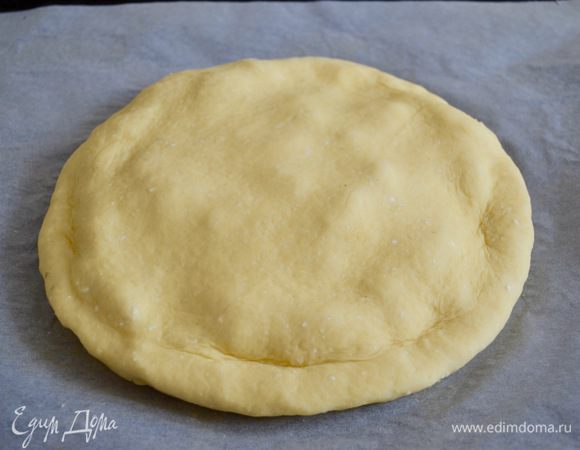 Вторую часть теста раскатать в лепешку чуть большего размера. Накрыть начинку второй лепешкой и подогнуть край под низ пирога. 