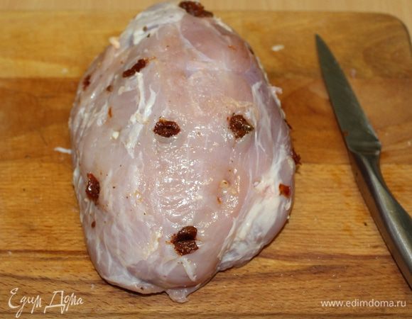 Мясо вымыть, обсушить бумажным полотенцем. Длинным ножом проделать отверстия в мясе. Дольки чеснока и помидоры порезать ломтиками и вставить в отверстия.