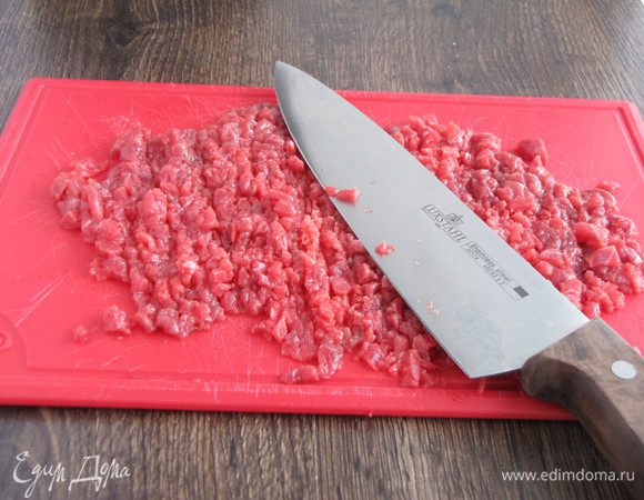 Затем тяжелым шефским ножом или кухонным топориком изрубить мясо в фарш. 