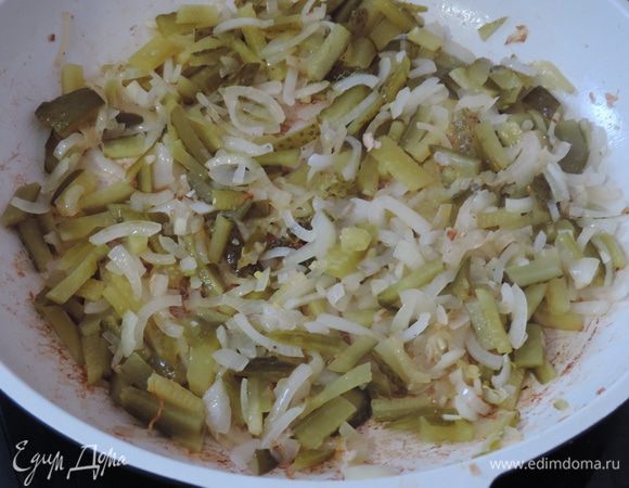 Лук нарезаем четвертькольцами и обжариваем до золотистого цвета на той же сковороде, где жарили мясо.
Затем добавляем на сковороду нарезаные соломкой соленые огурцы. Их точное количество зависит от ваших вкусовых пристрастий и размера огурцов.
Обжариваем минут 5.