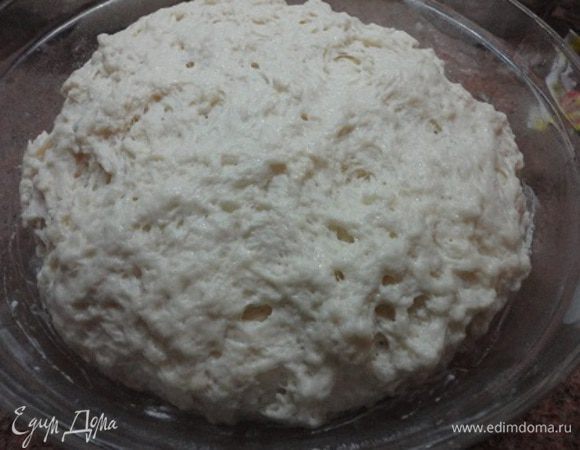 Добавить всю норму теплого молока и примерно 400 г муки. Замесить тесто и оставить его в теплом месте для брожения. Вот таким пористым оно стало примерно через час.