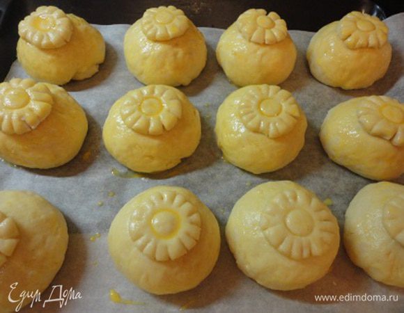 Подошедшие булочки смазываем желтком, укладываем цветочки и тоже смазываем желтком.