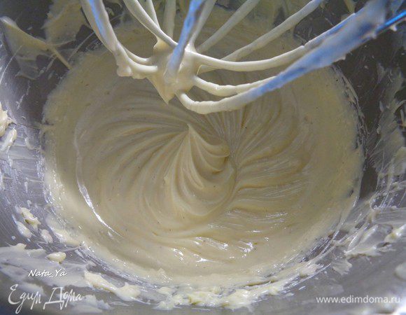 Переложите смесь в чашу миксера для взбивания. Когда она остынет до комнатной температуры, добавить несколько кубиков масла, взбить ручным или стационарным миксером на средней скорости. Добавлять масло по несколько кусочков, каждый раз хорошо взбивая миксером до однородности.
