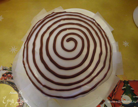 Коричневую помадку выложить в шприц с наконечником для надписей или в корнетик. Нарисовать тонкие круги шоколадной помадкой.