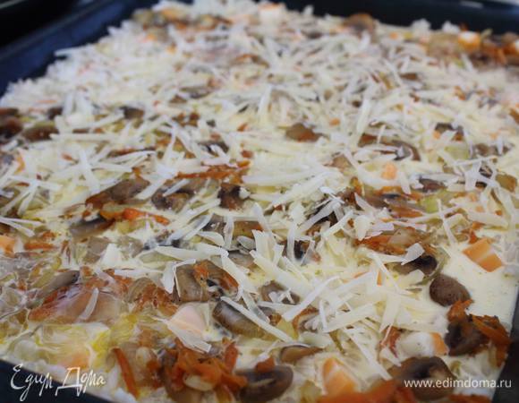 В противень, смазанный маслом, всыпаем отваренный рис, сверху грибы с луком и морковкой, подкладываем по периметру кубики моцареллы, зальем все это смешанными яйцами со сливками и посыпаем тертым сыром.
