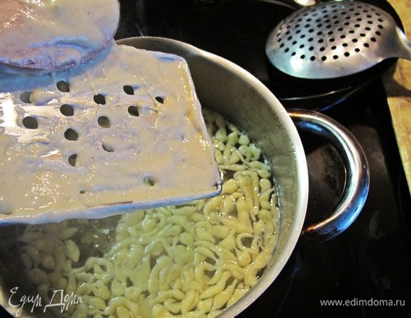 Тесто порциями протираем через терку в закипевшую воду.